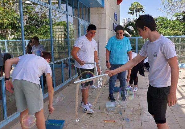 תלמידי מדעית ח’ חוקרים את נושא מתח הפנים במהלך שיעור העשרה